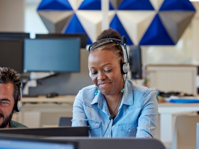 Conseillère clientèle devant un ordinateur et avec un casque audio