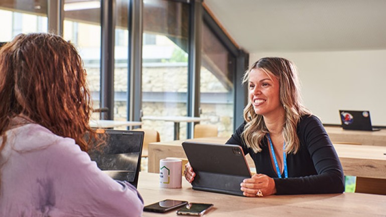 Deux femmes discutent dans un bureau