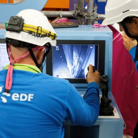 Essayeurs devant le poste de pilotage de la machine de manutention du combustible